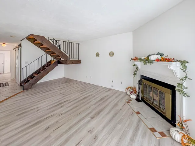 a view of a livingroom with wooden floor and a fireplace