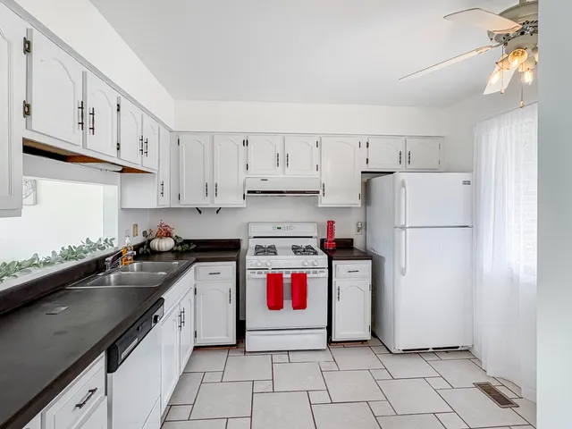 a kitchen with a sink a refrigerator and cabinets