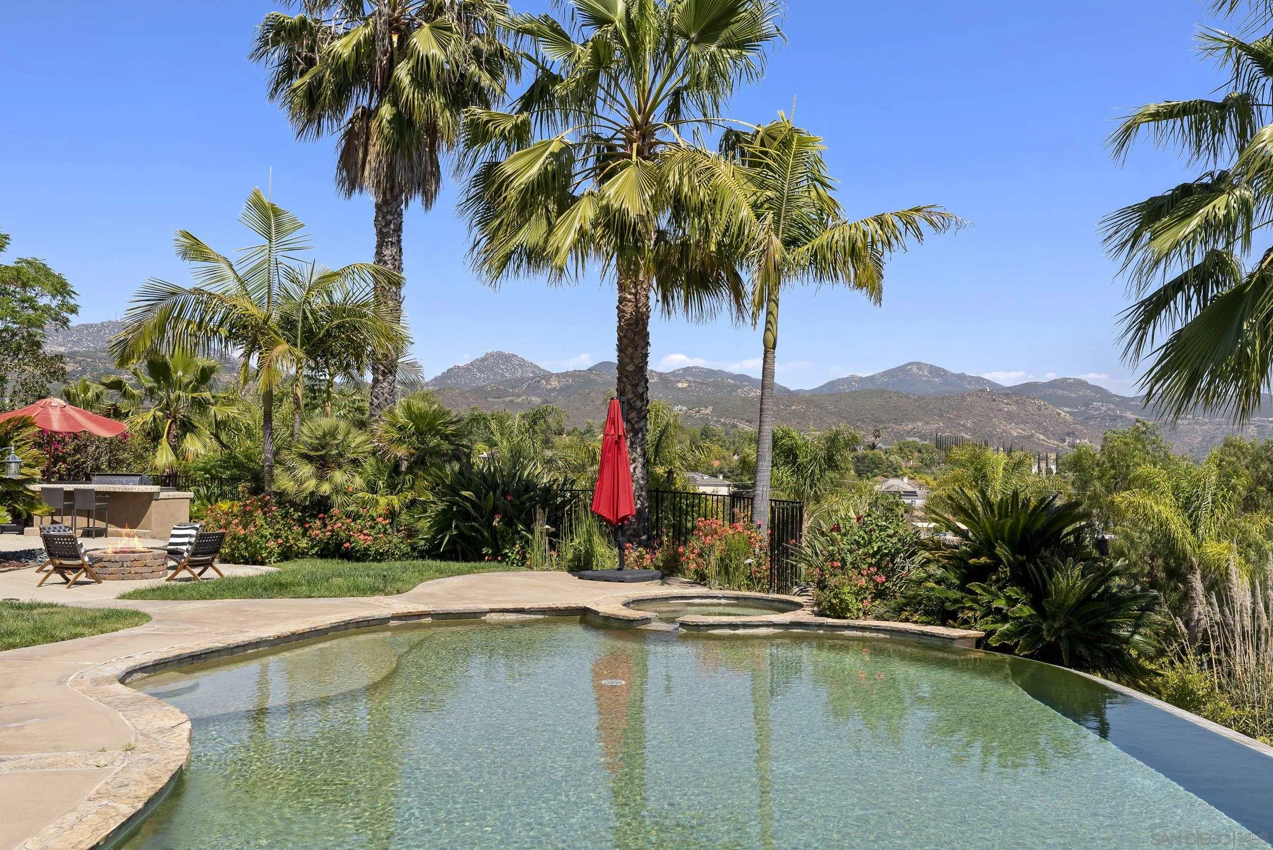 14998 Budwin Lane Poway, CA 92064 - Photo 37 of 44 a view of a swimming pool with a table and chairs