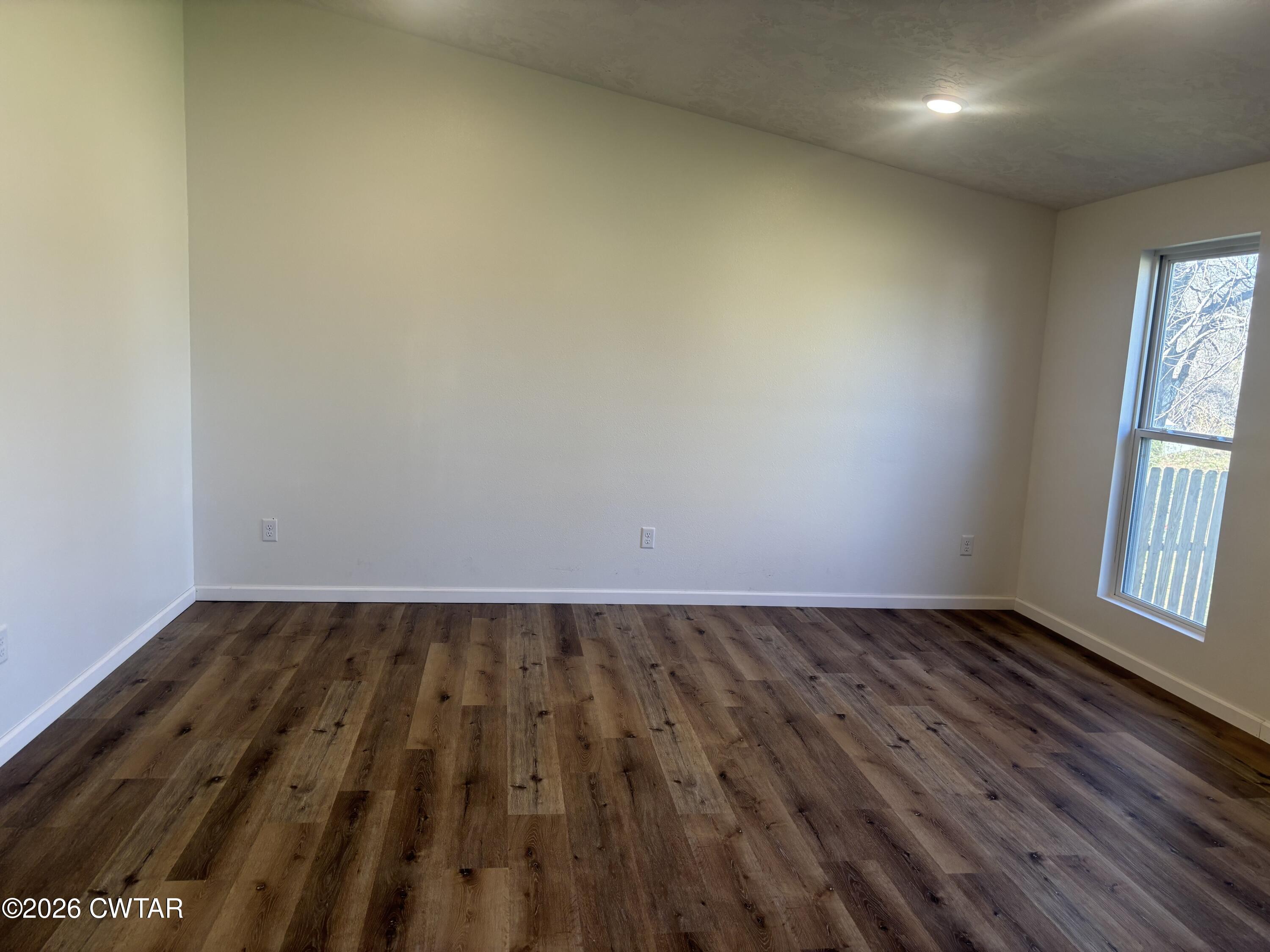 49 Primrose Drive Jackson, TN 38305 - Photo 13 of 20 an empty room with wooden floor and windows