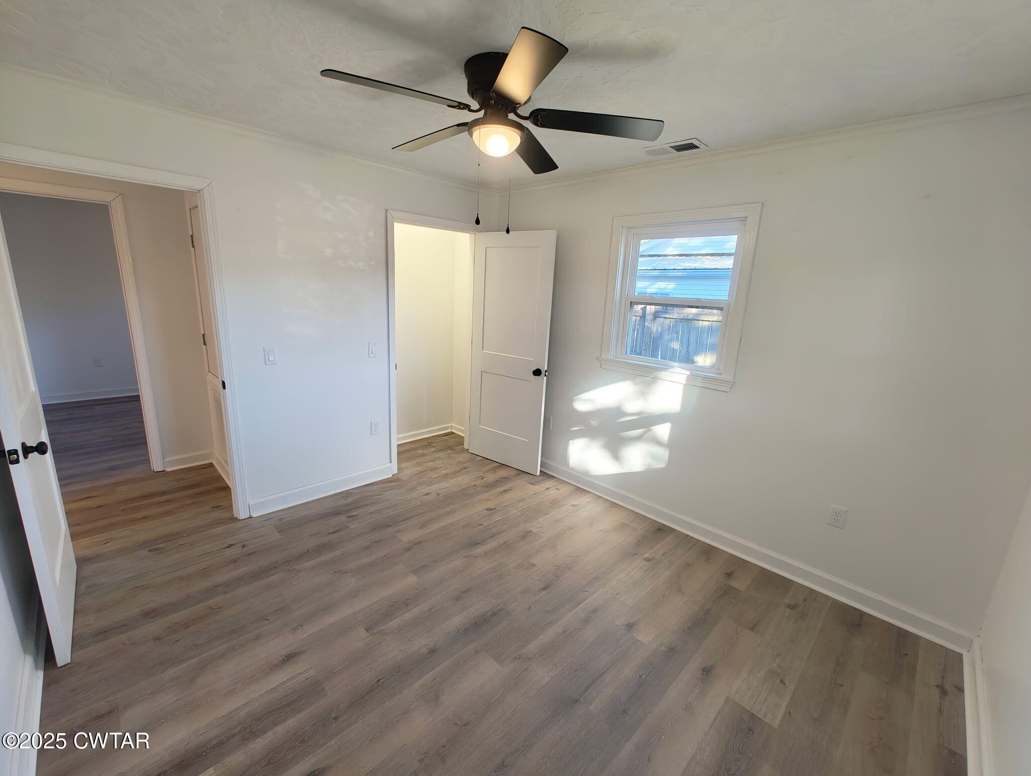 49 Primrose Drive Jackson, TN 38305 - Photo 6 of 20 a view of an empty room and wooden floor and a ceiling fan