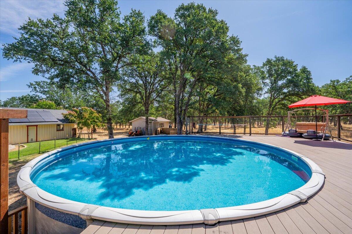 13185 Montecito Road Red Bluff, CA 96080 - Photo 27 of 36 a small pool with lawn chairs under an umbrella