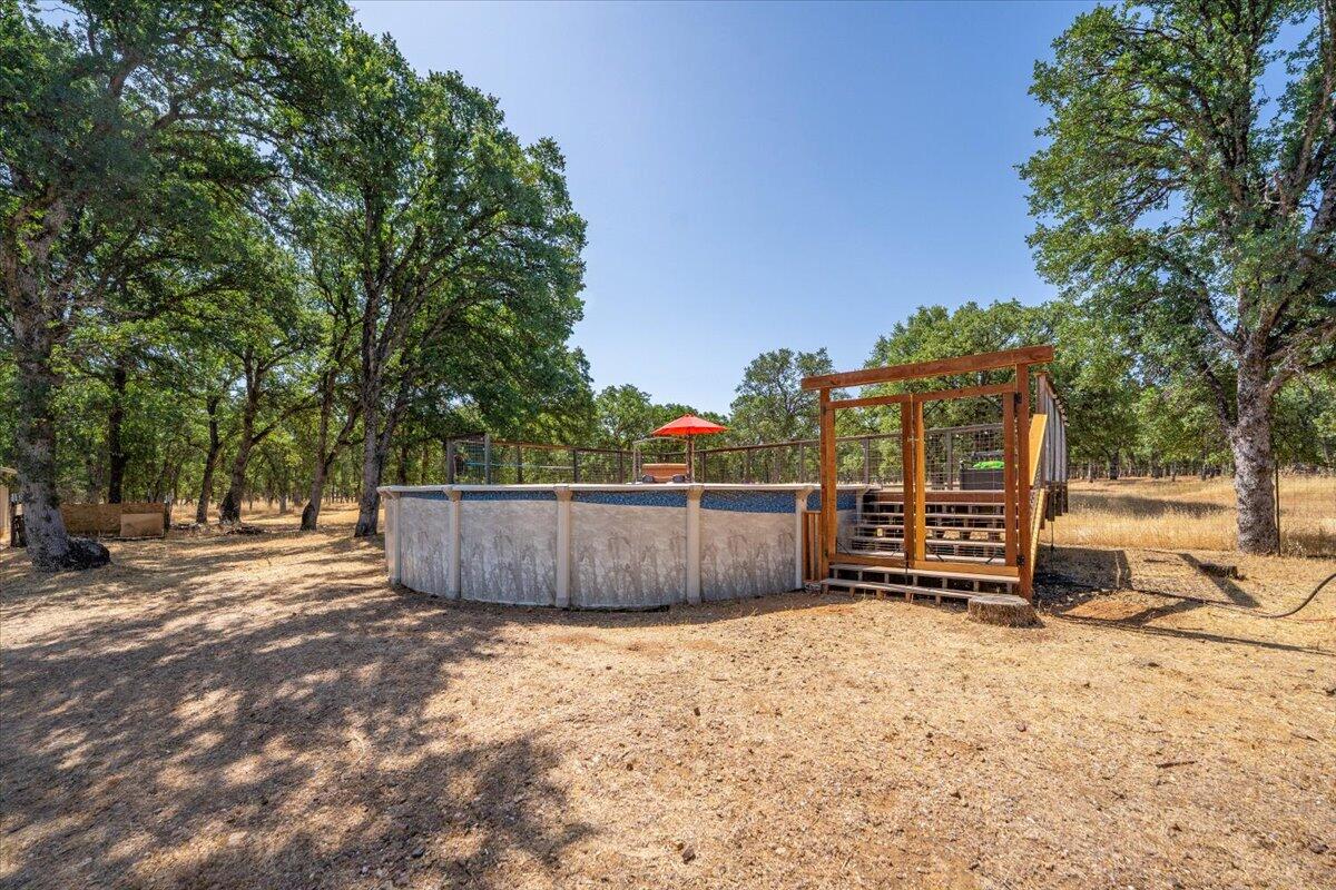 13185 Montecito Road Red Bluff, CA 96080 - Photo 28 of 36 a view of a backyard with wooden fence and large trees