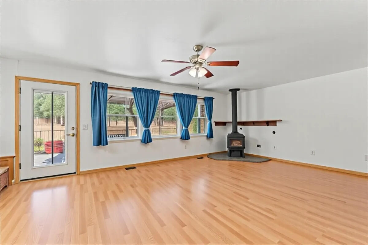 13185 Montecito Road Red Bluff, CA 96080 - Photo 9 of 36 a view of an empty room with window and wooden floor