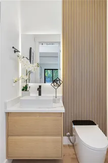 a bathroom with a sink a toilet and mirror