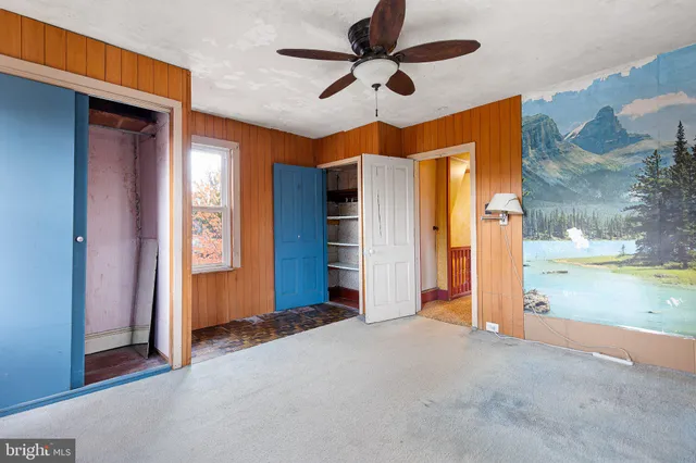 a view of a livingroom with a space & a ceiling fan