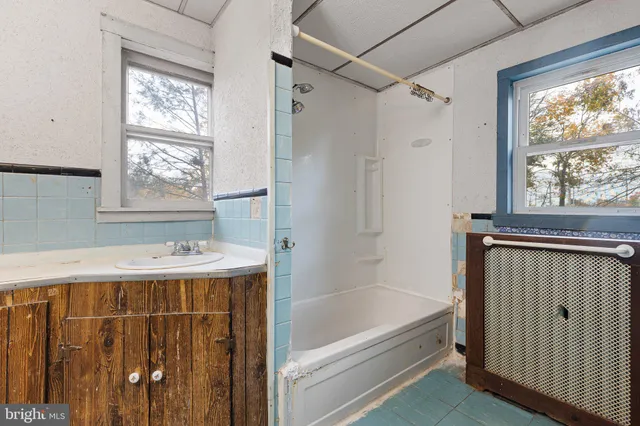 a bathroom with a bathtub a sink and a window