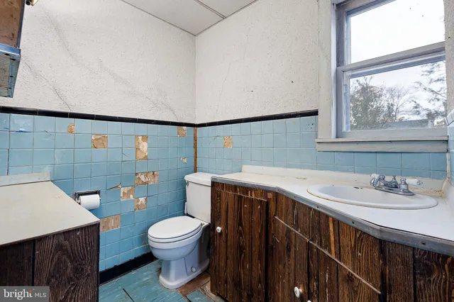 a bathroom with a sink a toilet and shower curtain