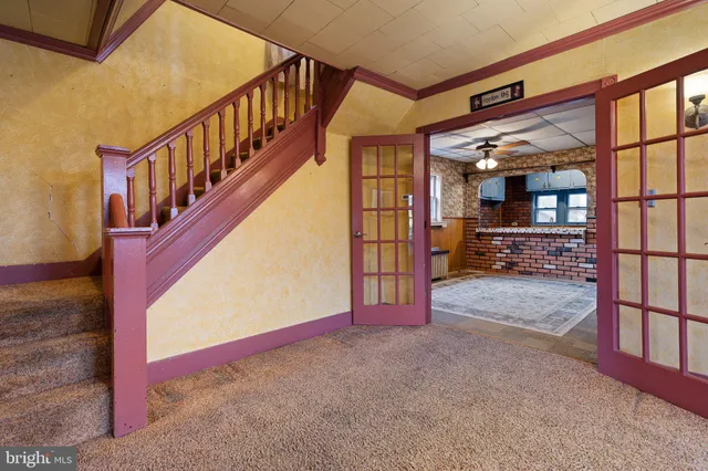 an empty room with windows and ceiling fan