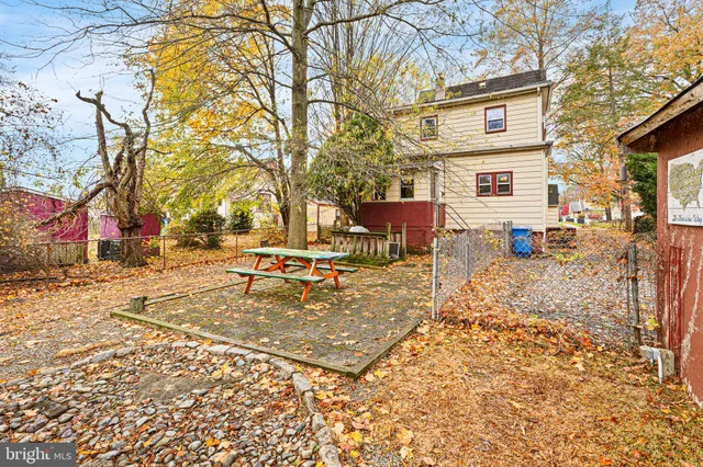 a view of a white house with large windows and a small yard