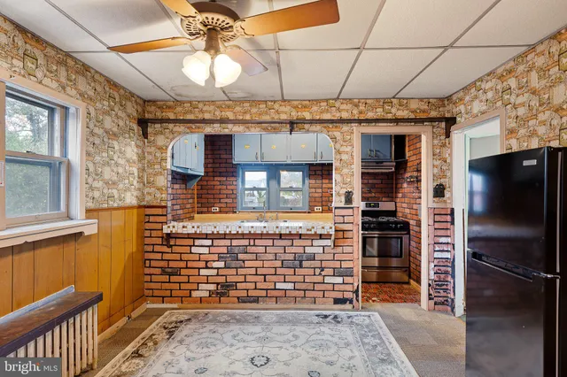 a view of a livingroom with a windows and ceiling fan