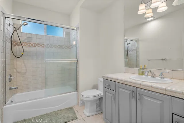 a bathroom with a granite countertop sink a toilet and shower