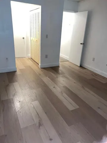 an empty room with wooden floor and closet