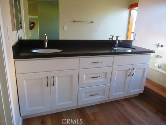 a close view of a sink a mirror and cabinets