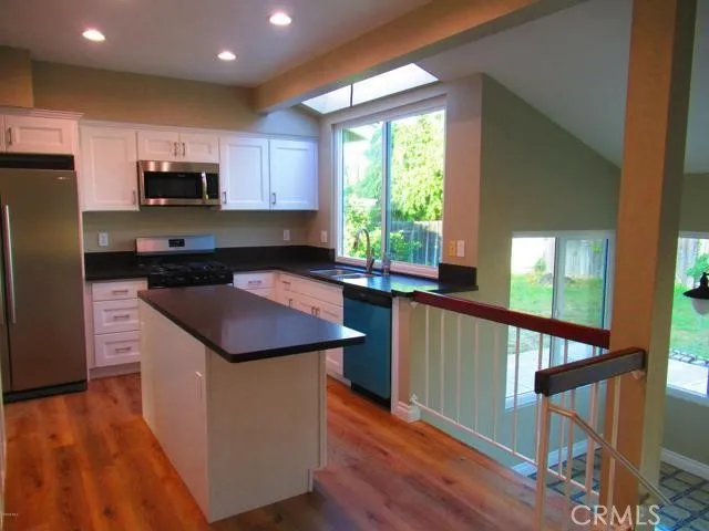 a kitchen with stainless steel appliances granite countertop a stove a sink and a refrigerator