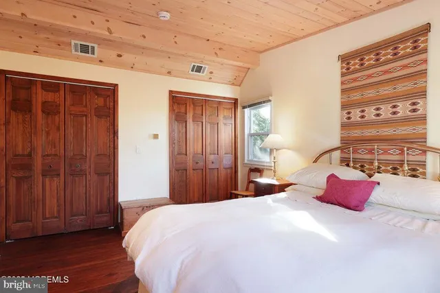 a bedroom with a large bed and wooden floor