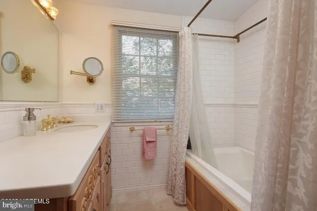 a bathroom with a granite countertop sink a bathtub and shower