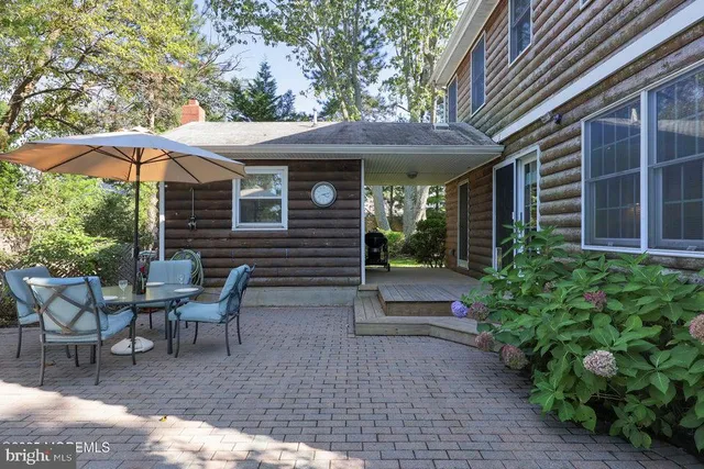 a view of a patio with table and chairs under an umbrella