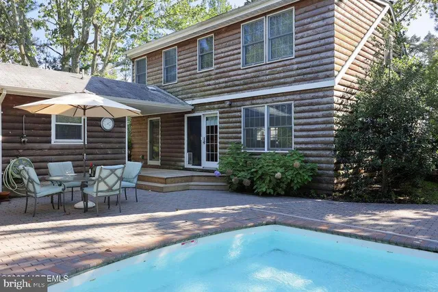 a view of a house with backyard and sitting area