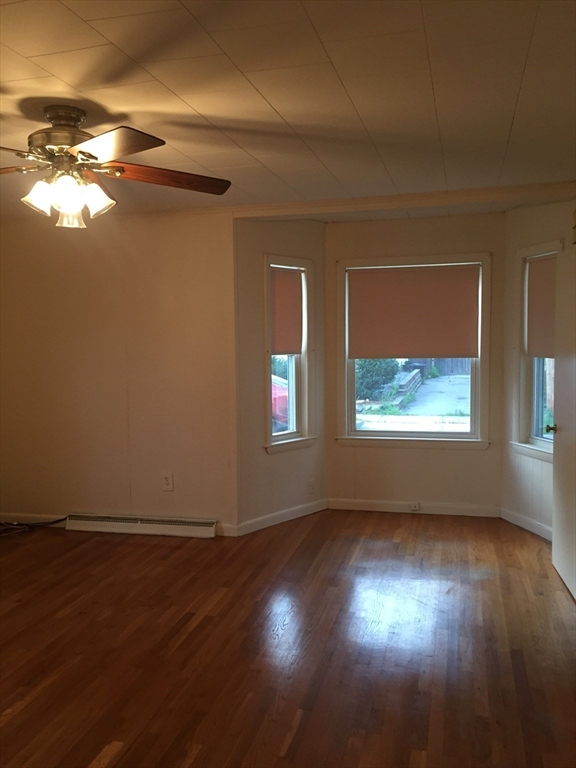 15 Green Street Reading, MA 01867 - Photo 15 of 34 a view of an empty room with wooden floor and a window