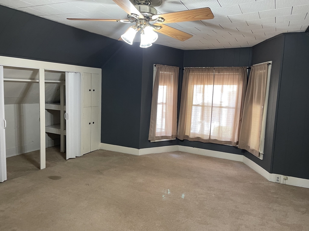 15 Green Street Reading, MA 01867 - Photo 18 of 34 an empty room with chandelier fan and windows