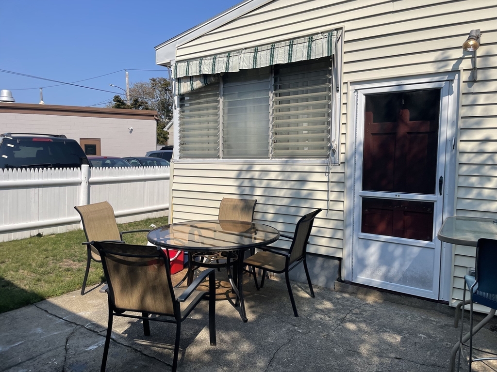 15 Green Street Reading, MA 01867 - Photo 28 of 34 a view of a patio with table and chairs with wooden floor and fence