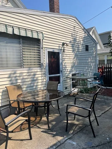 a view of a house with backyard and sitting area