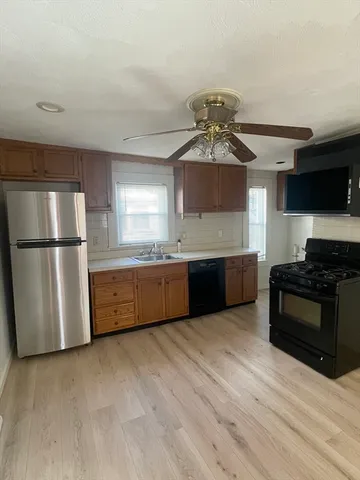 a kitchen with stainless steel appliances granite countertop a refrigerator a sink dishwasher a stove and a refrigerator