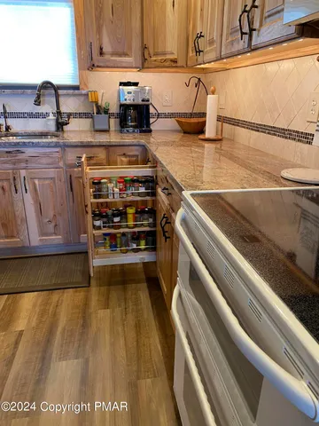 a kitchen with stainless steel appliances granite countertop a stove a microwave and wooden cabinets