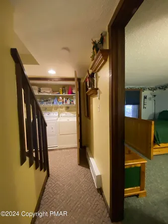 a living room with a bed and a refrigerator