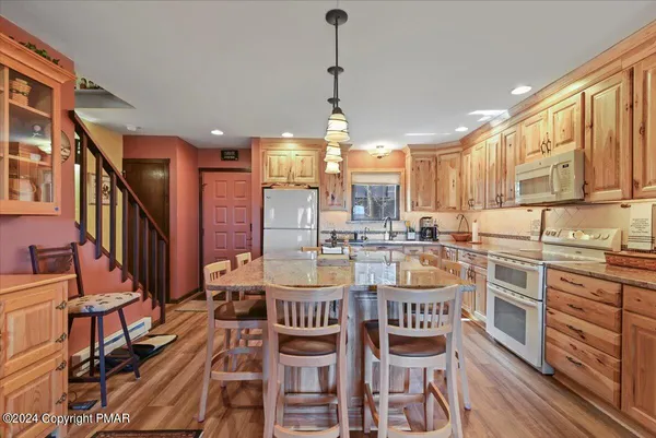 a kitchen with stainless steel appliances granite countertop a kitchen island a stove a table and chairs