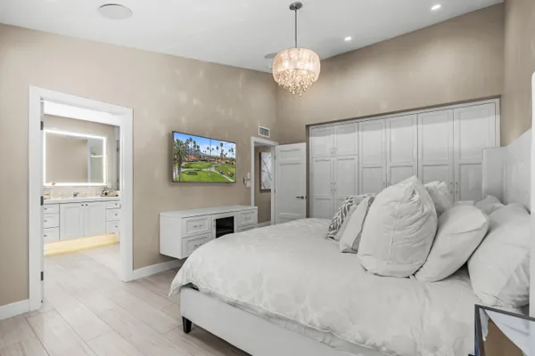 a spacious bedroom with a bed and a chandelier