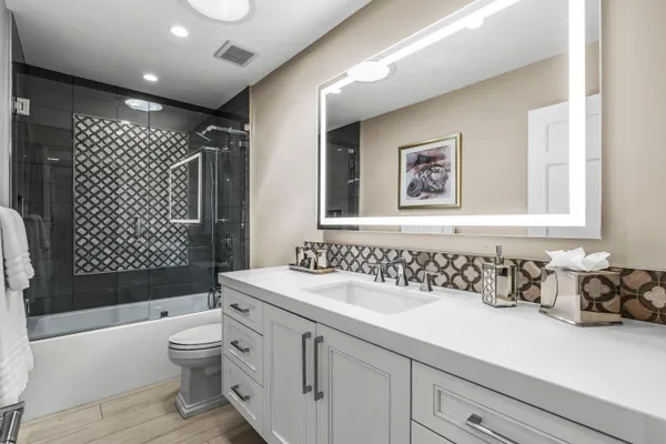 a bathroom with a sink a toilet and shower