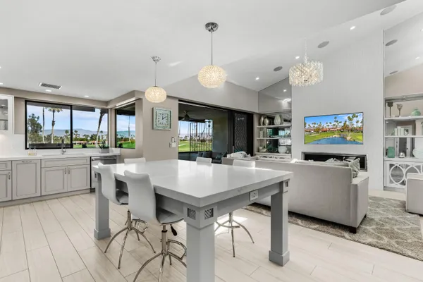 a living room with furniture a flat screen tv and kitchen view