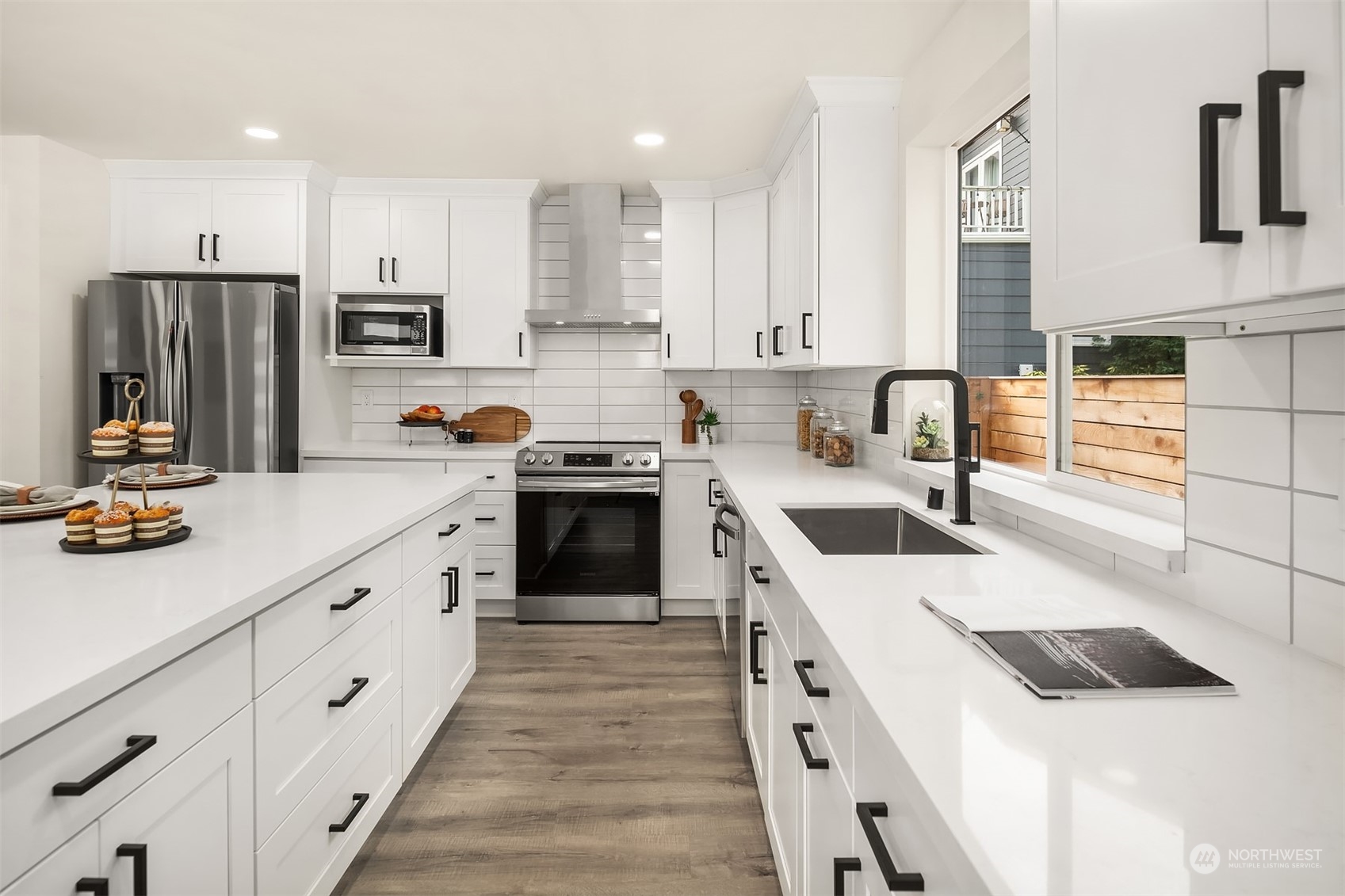4915 South Genesee Street Seattle, WA 98118 - Photo 3 of 10 a kitchen with stainless steel appliances sink a stove and cabinets