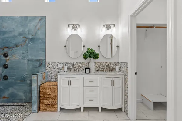 a bathroom with a double vanity sink mirror and shower