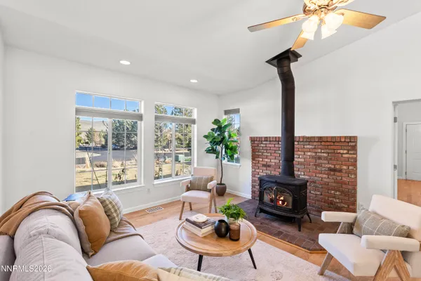 a living room with furniture a fireplace and a floor to ceiling window