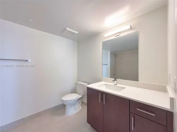 a bathroom with a sink a toilet a mirror and vanity