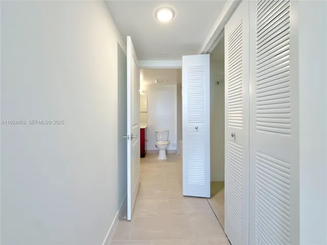 a view of a hallway with a livingroom and a bathroom