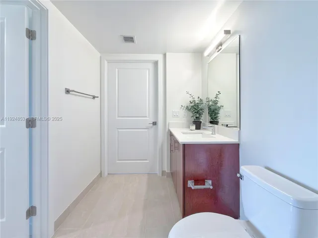 a bathroom with a sink a toilet a mirror and shower