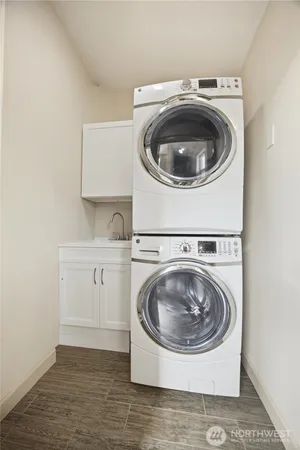 a utility room with wooden floor and washing machine
