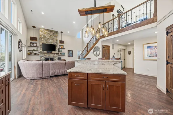 a living room with stainless steel appliances kitchen island granite countertop wooden floor and a view of living room