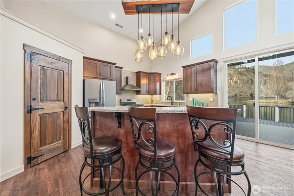 a view of a dining room with furniture a chandelier and wooden floor