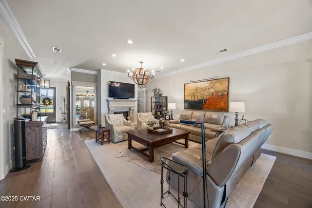 a kitchen with granite countertop a kitchen island white cabinetry and refrigerator