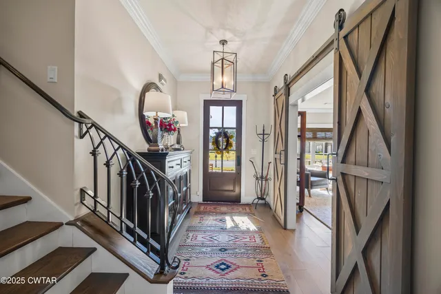 a living room with furniture a flat screen tv and a floor to ceiling window