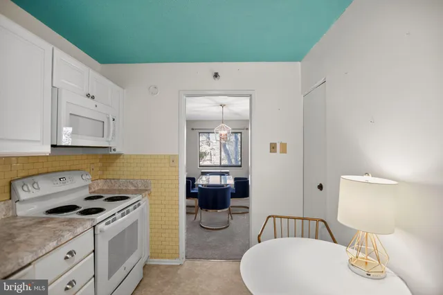 a kitchen with a white stove top oven and cabinets