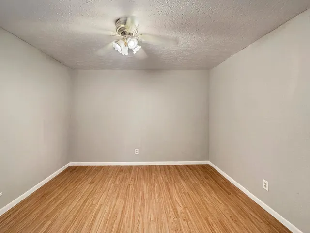 a view of a room with wooden floor and fan