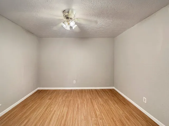 a view of a room with wooden floor and fan
