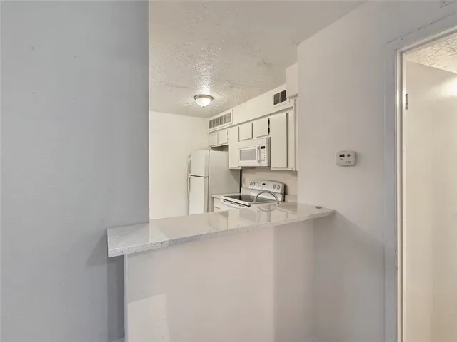 a kitchen with kitchen island a sink appliances and cabinets