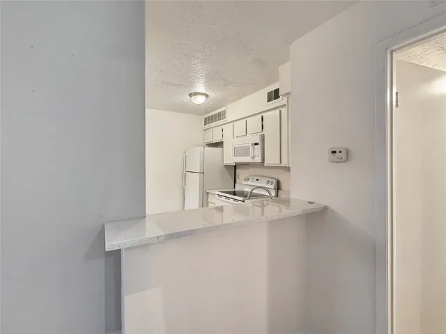 a kitchen with kitchen island a sink appliances and cabinets